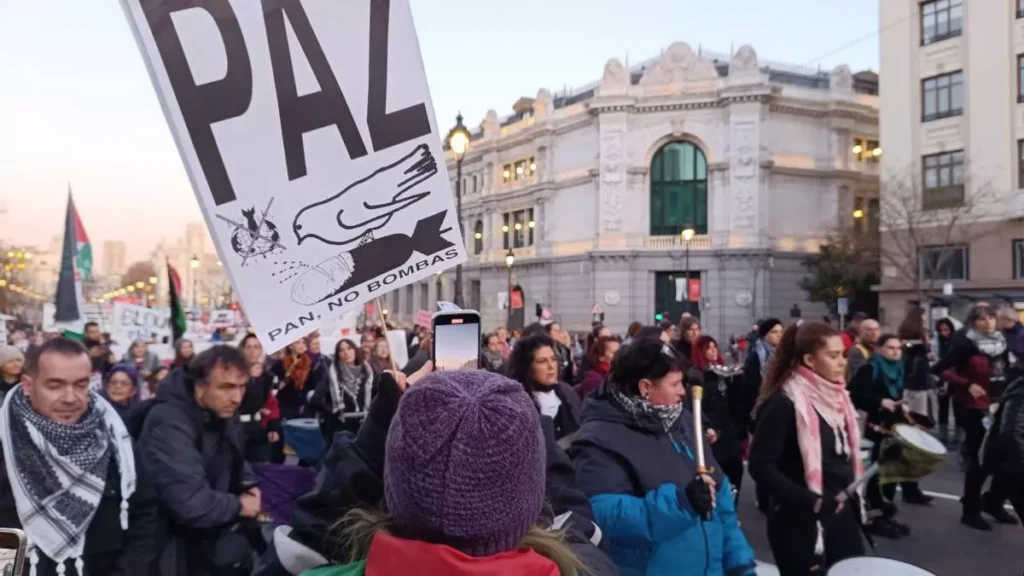 Una mujer sostiene una pancarta con las palabras 'Paz. Pan. No bombas' durante la manifestación de este sábado en Madrid. Foto.- Guillermo Martínez