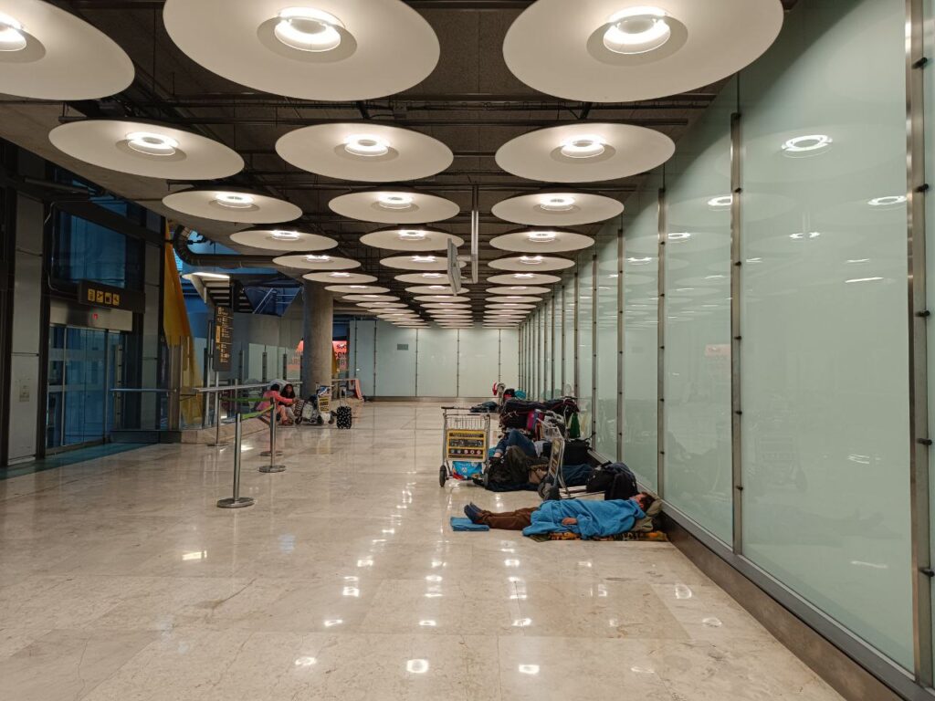 Varias personas duermen en el aeropuerto de Madrid-Barajas. Guillermo Martínez