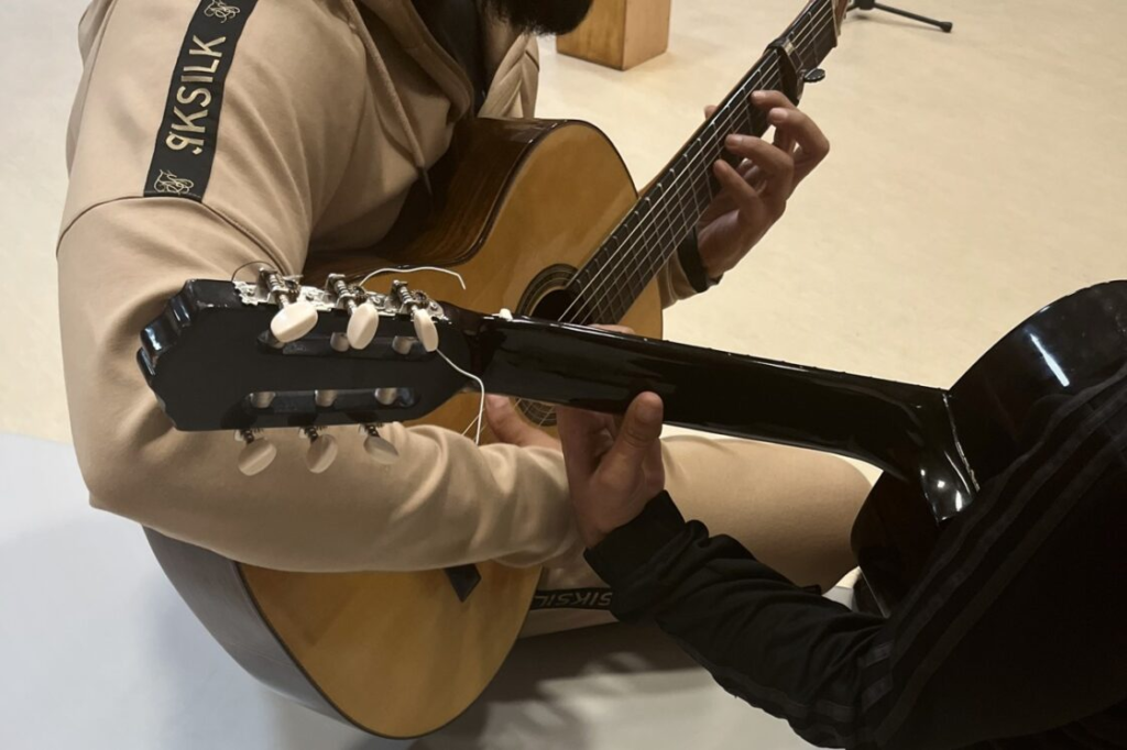 Dos internos tocan la guitarra en el taller musical del Centro Penitenciario Madrid VII.- Cedida